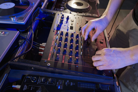 Hands working sound equipment.