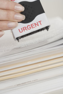Woman stamping paperwork as urgent.