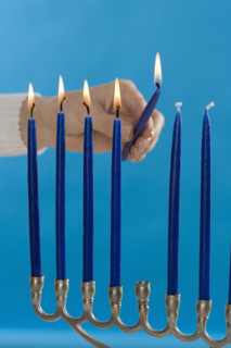 Woman lighting a Menorah.