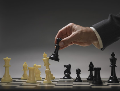 Businessman moving chess piece.