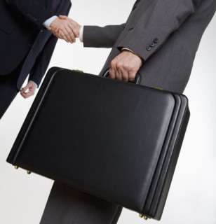 Businessman with briefcase shaking hands.