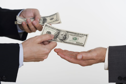 Businessman giving money to a man.
