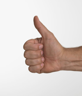 Studio shot of man's hand giving thumbs up.