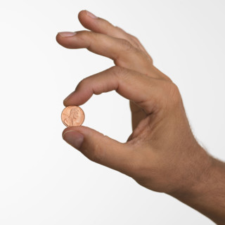 Close up studio shot of man holding penny.