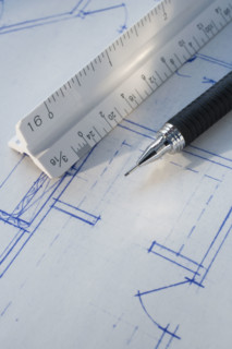 Close up of ruler and pen on blueprints.