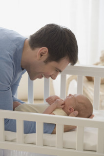 Father smiling at newborn baby.