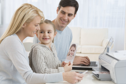 Family printing pictures with laptop.