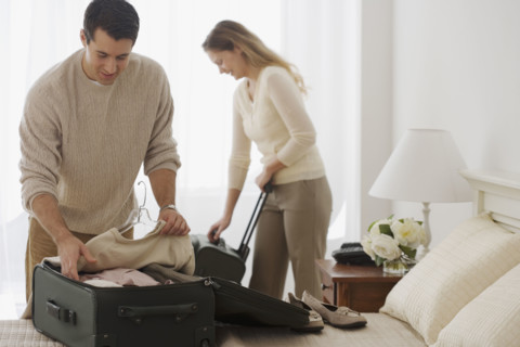 Couple unpacking in hotel room.