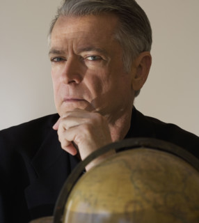 Senior businessman next to globe.
