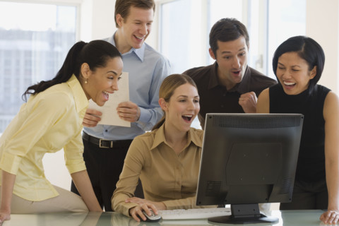 Group of businesspeople looking at computer.