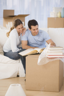 Couple unpacking books in new house.