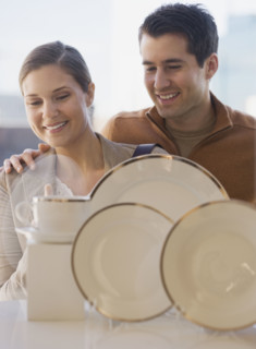 Couple looking at tableware in shop window.