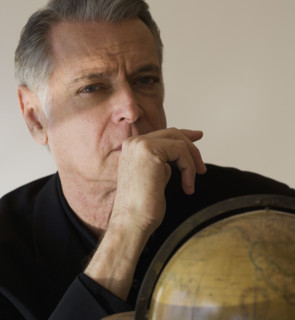 Senior businessman next to globe.