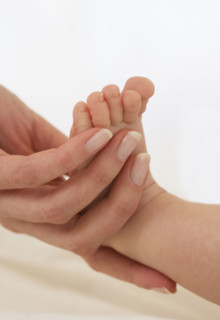 Mother holding baby’s foot.