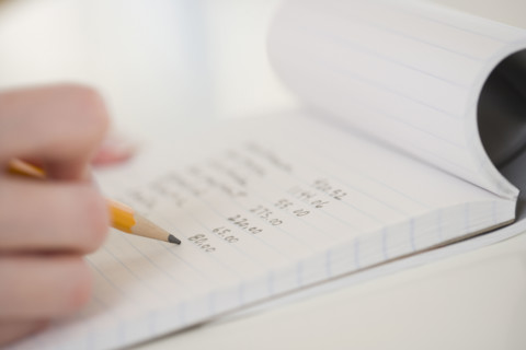 Close up of woman writing in notebook.