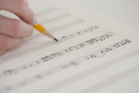 Close up of woman writing music.