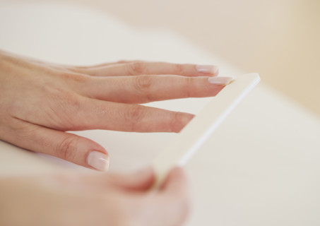 Close up of woman filing fingernails.