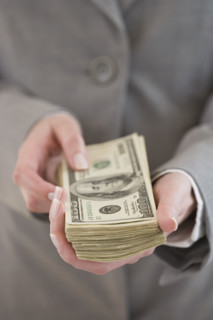 Businesswoman holding stack of money.