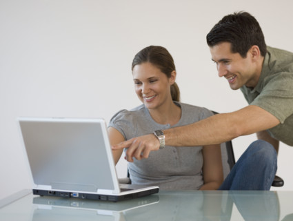 Couple pointing at laptop.
