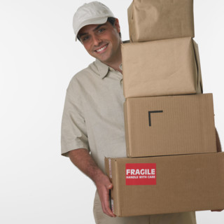 Studio shot of deliveryman holding stack of boxes.