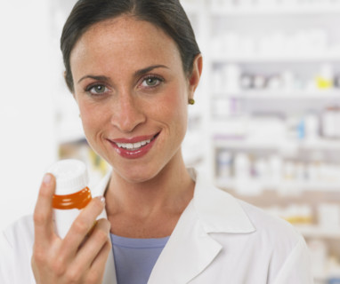 Close up of female pharmacist holding medication.