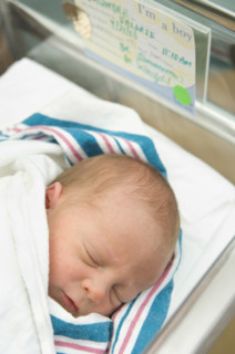 Newborn baby in hospital bed.