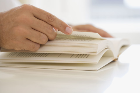 Man turning page of book.
