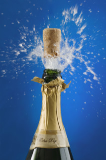 Close up of champagne cork popping.
