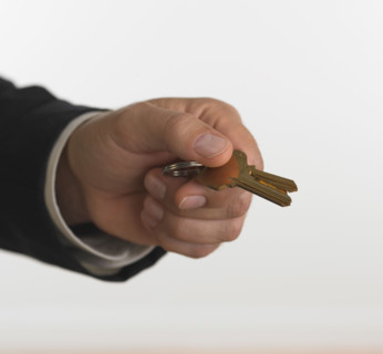 Studio shot of businessman holding keys.