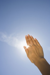 Close up of woman's hand blocking sun.