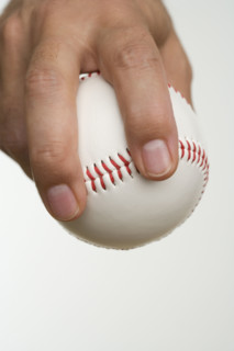 Close up of pitcher holding baseball.