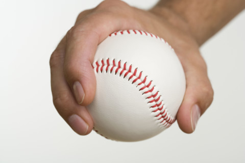 Close up of pitcher holding baseball.
