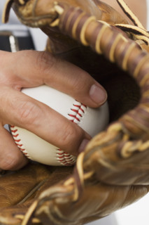 Close up of man with baseball glove and baseball.