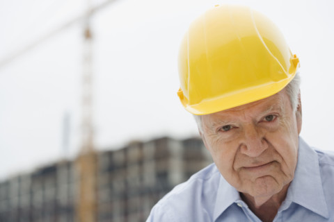 Senior man wearing hard hat.