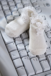Close up of baby booties on computer keyboard.