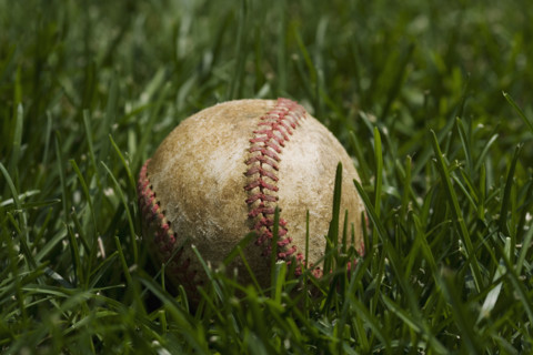 Close up of baseball in grass.