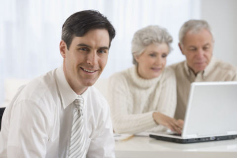 Portrait of businessman with senior couple in background.
