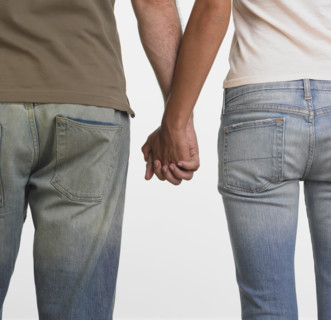 Rear view of couple holding hands.