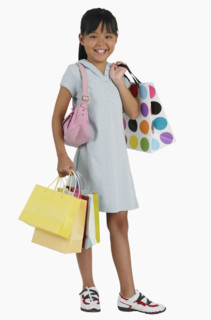 Studio shot of girl carrying shopping bags.