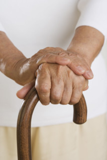Close up of senior's hands on cane.