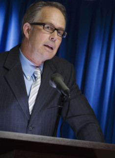 Close up of businessman speaking at podium.