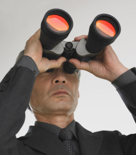 Businessman looking through binoculars.
