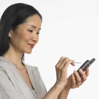 Studio shot of Asian woman using PDA.