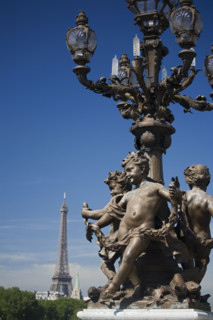 Lamp post with cherubs and Eiffel Tower in background.