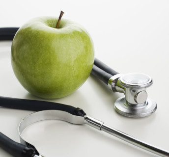 Studio shot of apple and stethoscope.