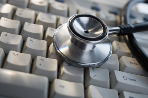 Close up of stethoscope on computer keyboard.