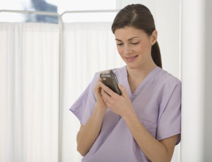 Female doctor looking at electronic organizer.
