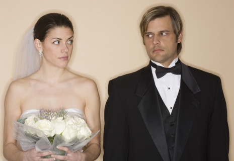Angry bride and groom looking at each other.