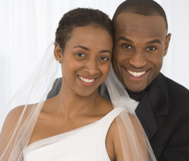 Portrait of bride and groom hugging.