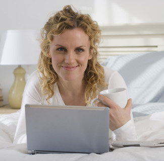 Portrait of woman with laptop and coffee.